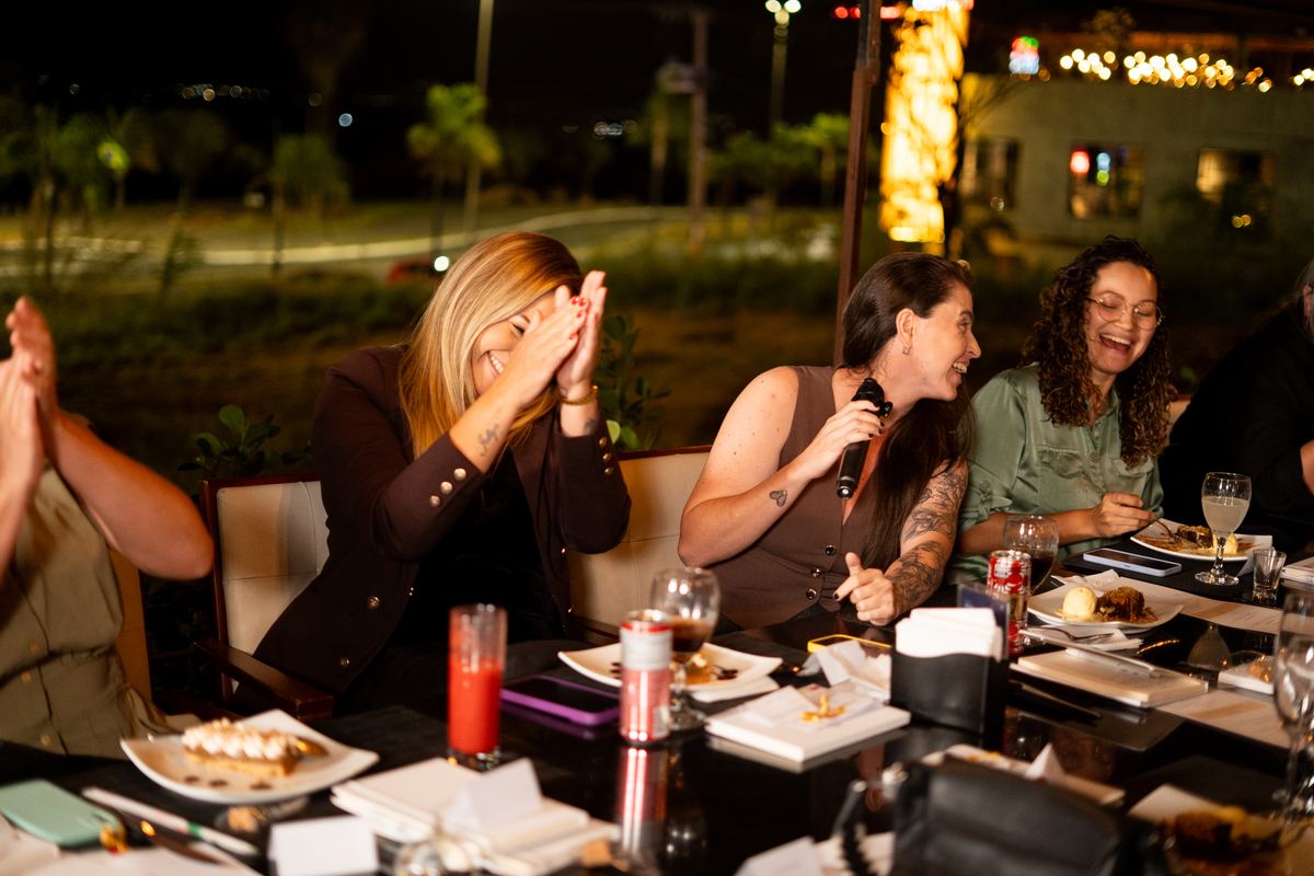 Participantes conversando à mesa durante o jantar.