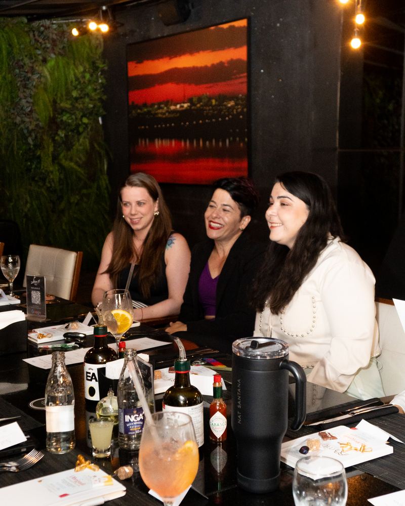 Mesa longa com as participantes conversando durante o jantar.
